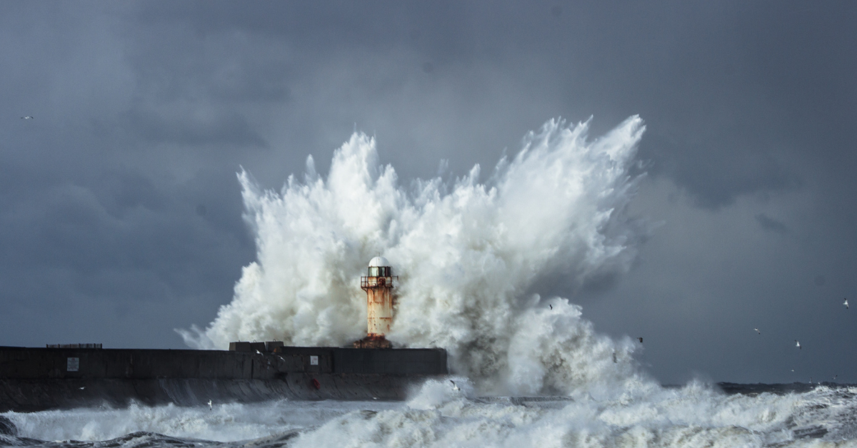 Large wave crashing over a lighthouse during a severe UK storm